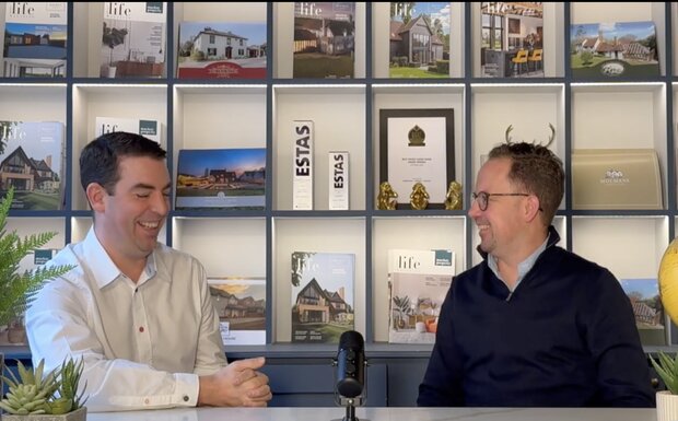 Adam Day and Adam Mackay pictured chatting in an office.
