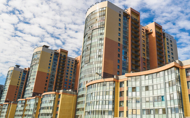 Modern high rise apartments in England pictured against a blue sky.